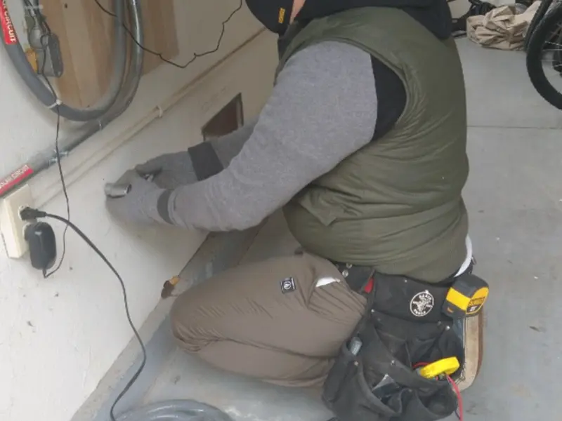 Electrician performing outlet wiring in a Struthers garage